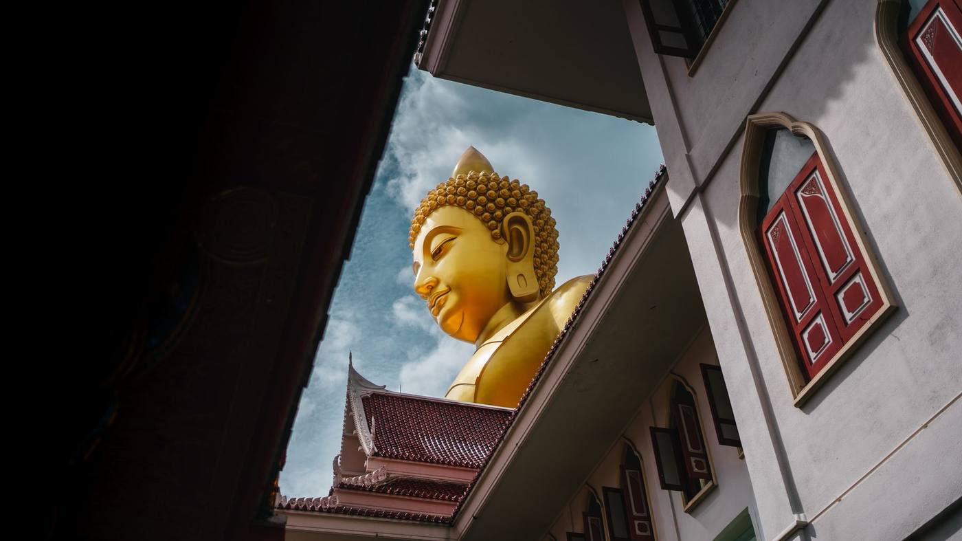 A gilded statue above a temple roof